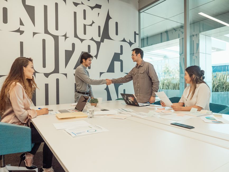 A diverse team of professionals discussing and collaborating in a modern office setting.
